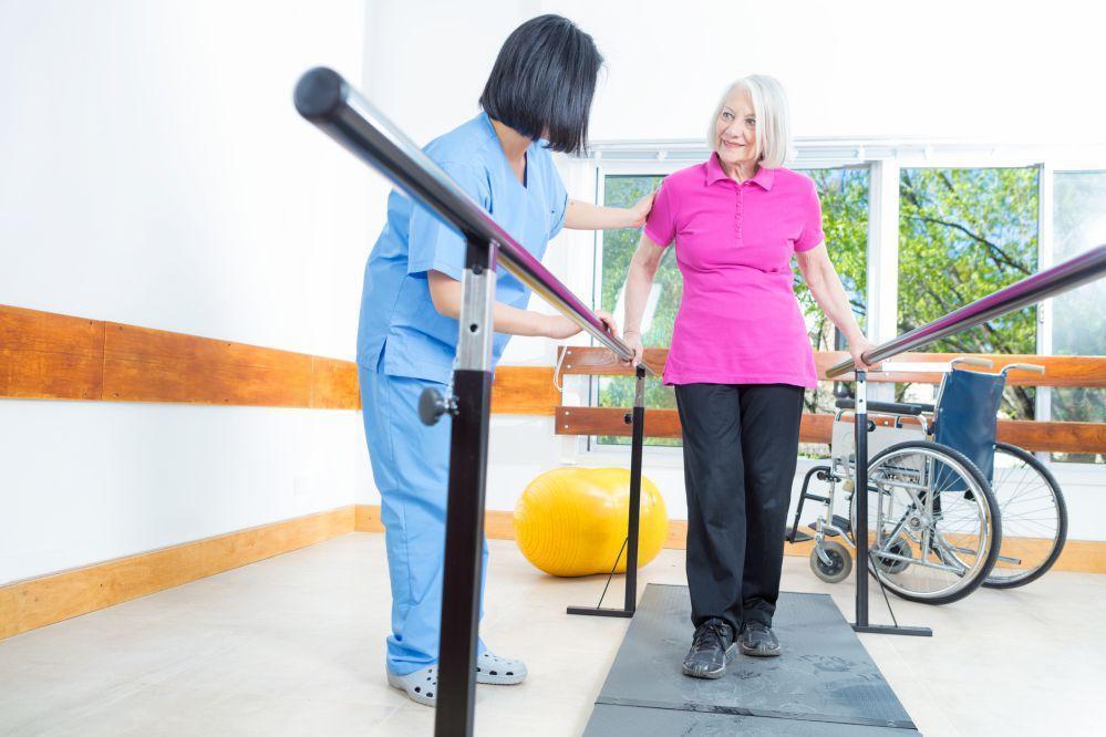 Starsza pani podczas sesji rehabilitacyjnej